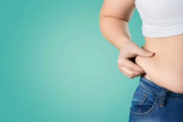 Image of woman pinching her love handles to show weight gain Netherton